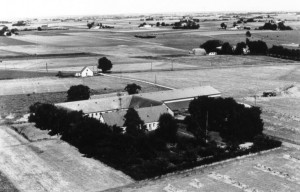 Udsigt over Hedeland før der blev gravet grus. Det er et næsten helt fladt landbrugsområde med større gårde og huse, som ligger omkring 55 m. over havets overfalde. Billedet er fra før 1956 og viser Mindstrupgaard.